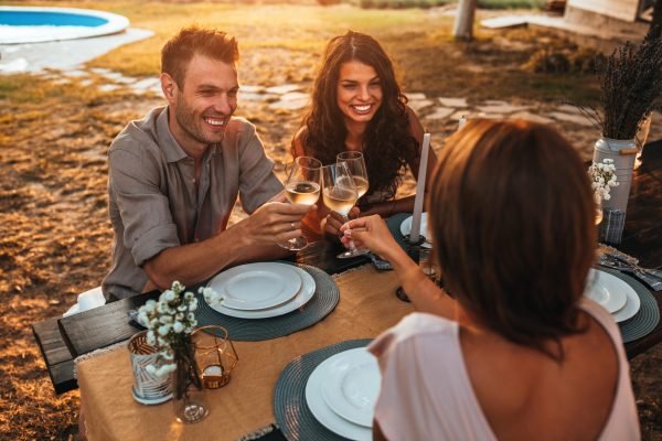 Toasting a special occasion Cropped shot of handsome smiling friends having dinner in the backyard